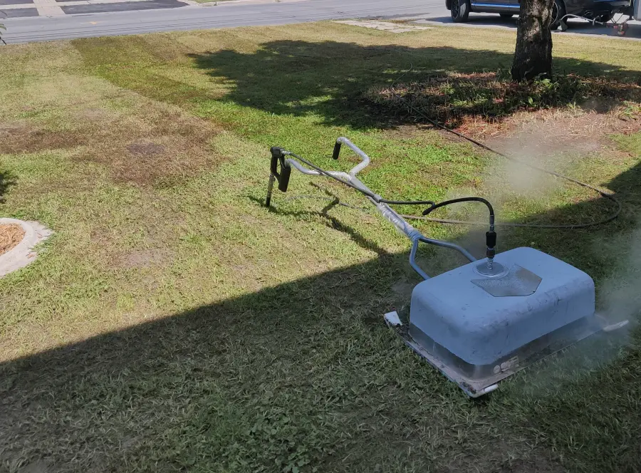 The saturated-steam weeding unit emitting steam over a front lawn