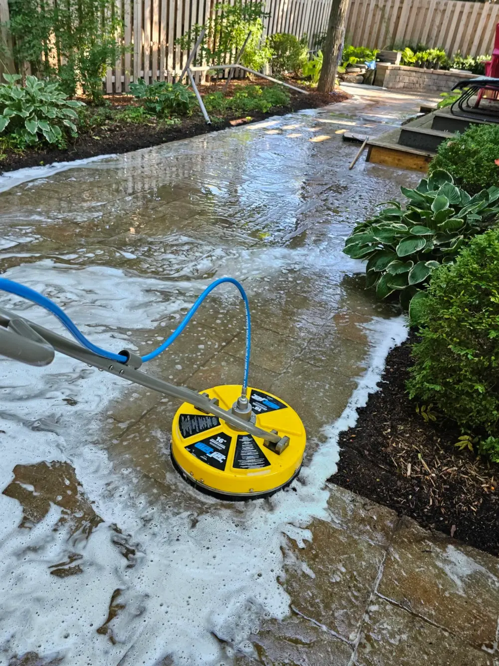 Commercial rotary surface cleaner washing an interlock walkway