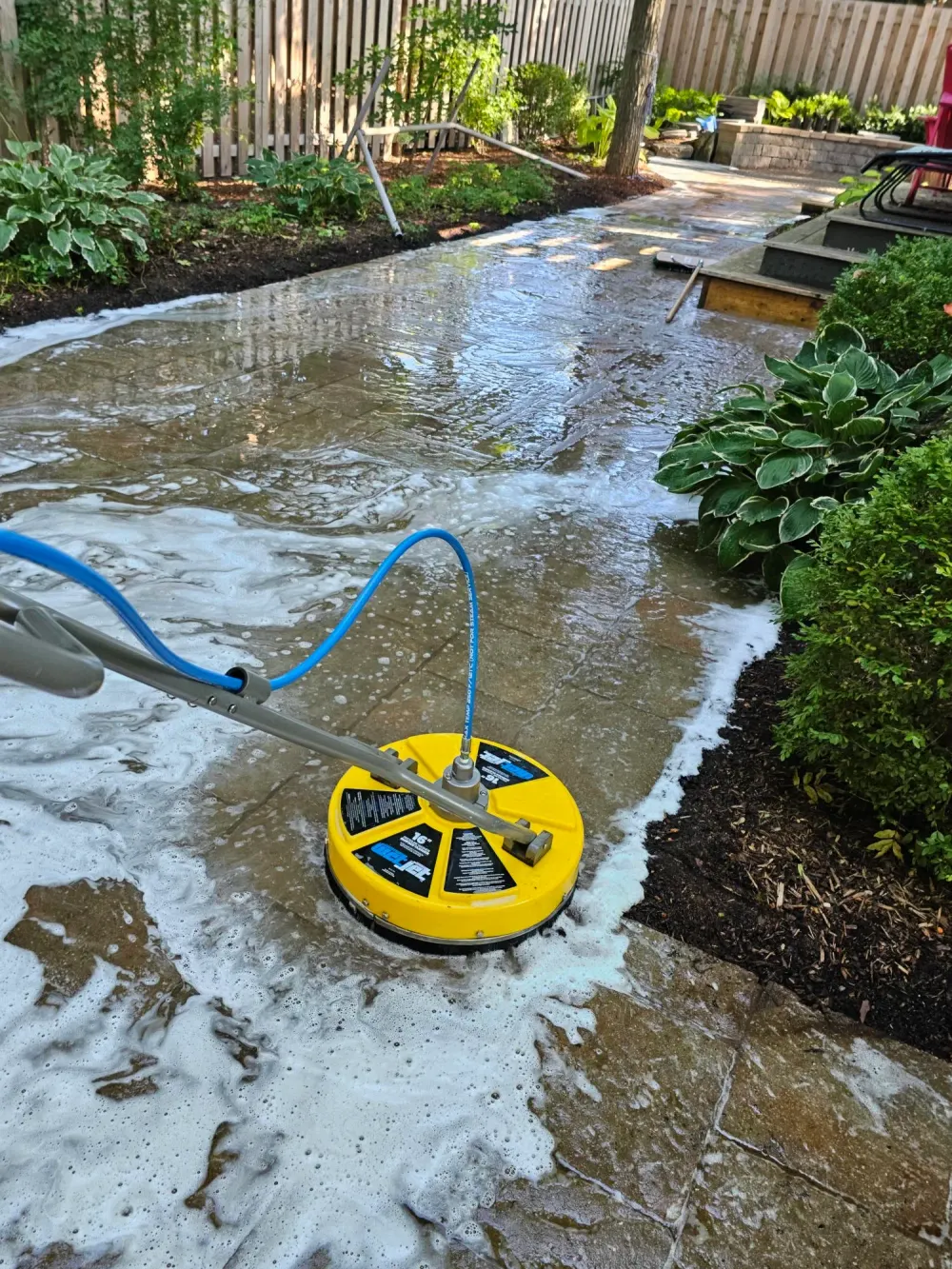 Commercial rotary surface cleaner washing an interlock walkway