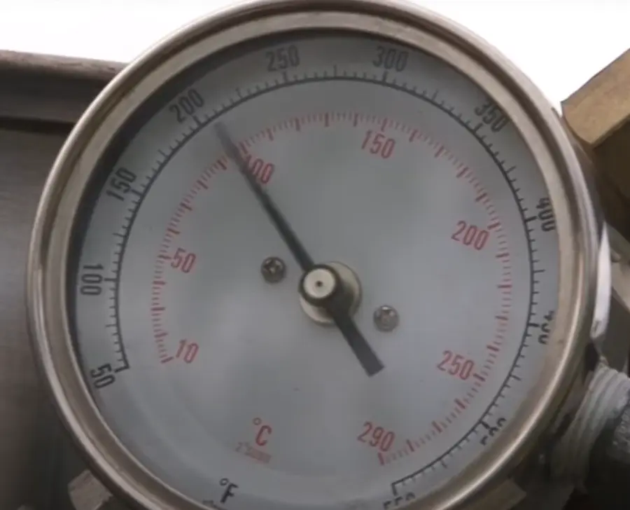 Close-up of the steam unit's temperature and pressure gauge in Celsius and Fahrenheit