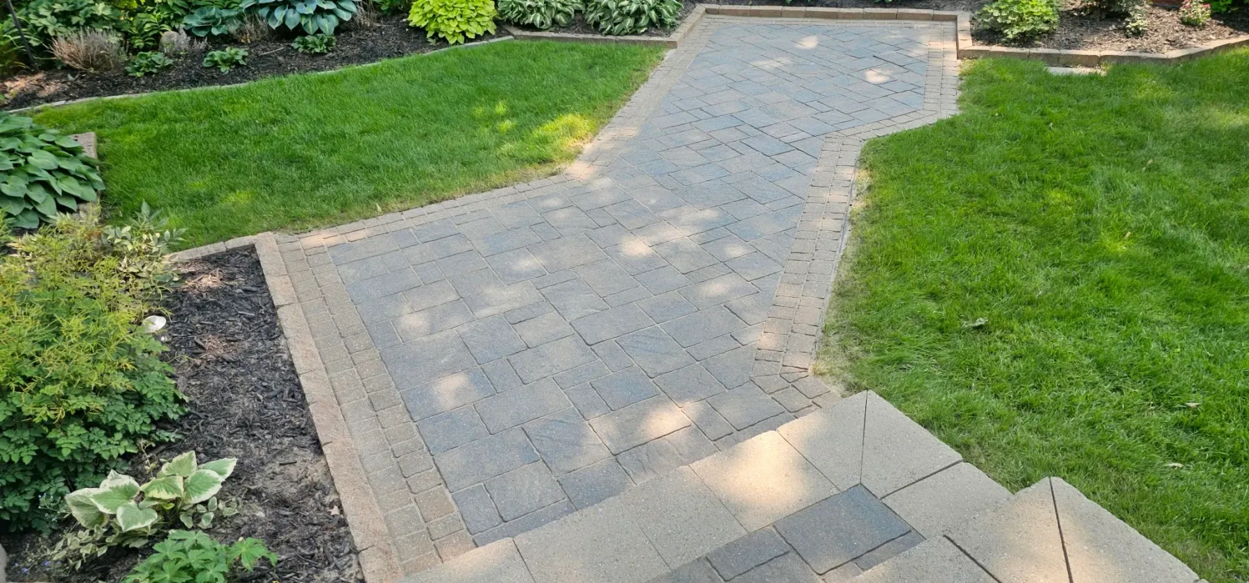S-curve walkway restored and re-sanded but unsealed — flat grey-tan pavers