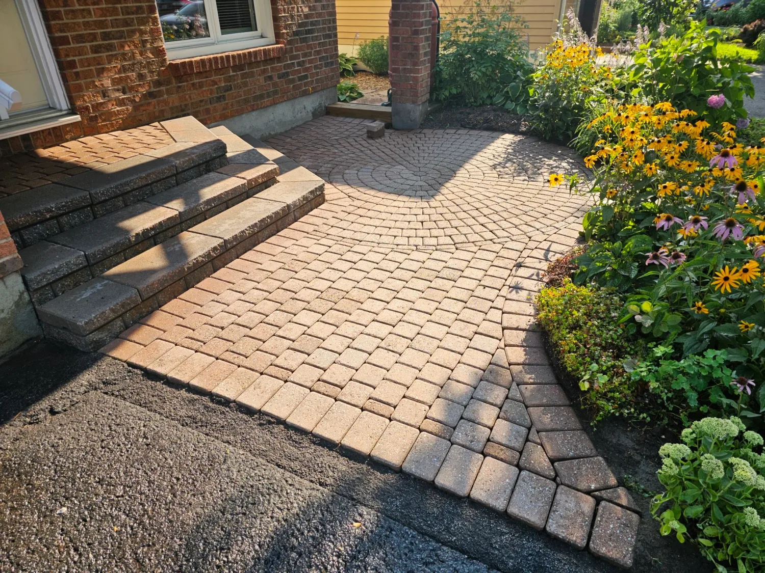 The same front-entry walkway cleaned — joints cleared out, colour revived in golden-hour light, ready for new sand