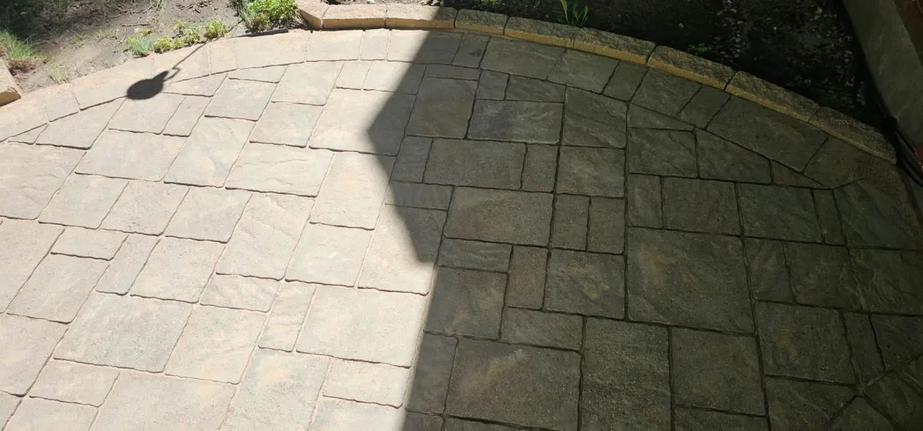 The same patio after compaction and sweeping — joints filled level across two-tone pavers