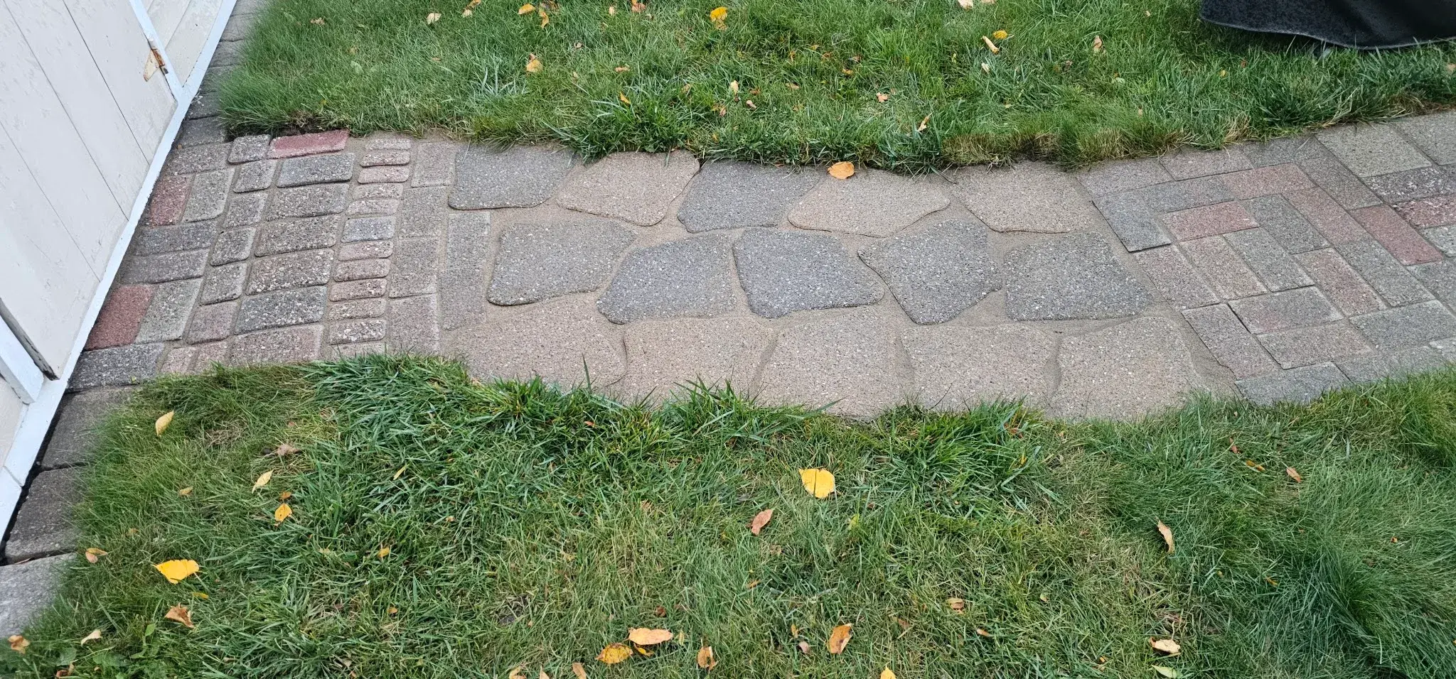 The same flagstone path re-set flush with joints packed and crisp lawn edges